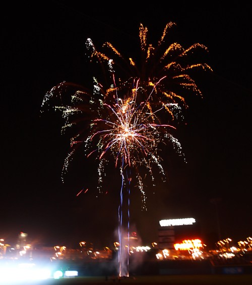 Colorful fireworks burst in the night sky, illuminating the darkness with vibrant sparks and trails.