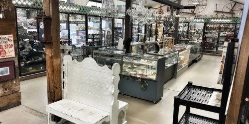 A spacious antique shop featuring glass display cases filled with various collectibles and vintage items.