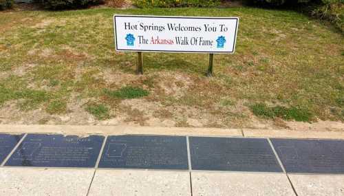 Sign welcoming visitors to Hot Springs and the Arkansas Walk of Fame, with engraved plaques on the ground.