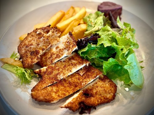 A plate featuring crispy fried fish fillets, golden fries, and a fresh green salad with leafy greens.