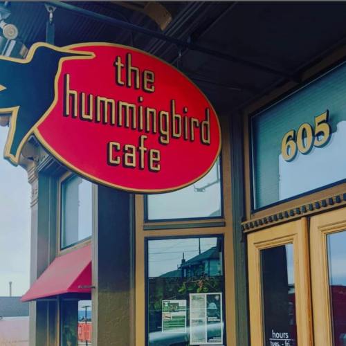 Sign for "The Hummingbird Cafe" with a red oval background, located at 605, featuring a hummingbird graphic.