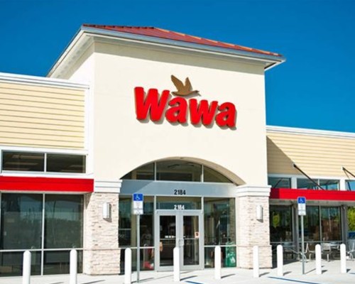 Exterior of a Wawa convenience store with a clear blue sky and red signage.