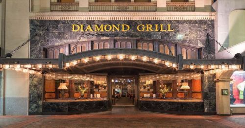 Exterior of Diamond Grill restaurant, featuring elegant lighting and a marble facade with the name prominently displayed.