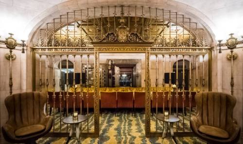 Elegant interior featuring ornate mirrors, plush seating, and decorative lighting in a sophisticated setting.