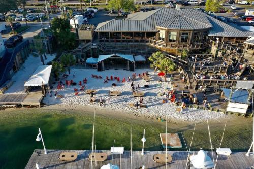 Aerial view of a beachside venue with people, red chairs, and a wooden building near the water.