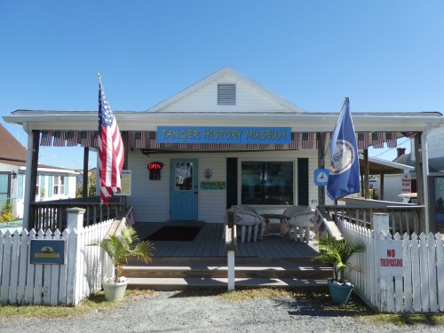 Exterior of the Tanger History Museum, featuring flags, a sign that says "OPEN," and a welcoming porch.