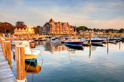 A serene marina at sunset, featuring boats docked and a charming waterfront building in the background.