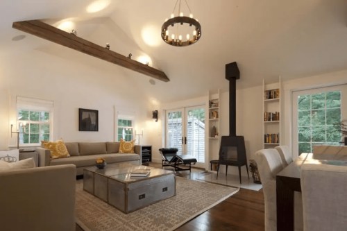 Cozy living room with a modern design, featuring a fireplace, large windows, and stylish furniture.