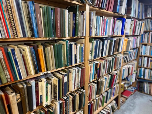 A cozy library with wooden shelves filled with a variety of colorful books.