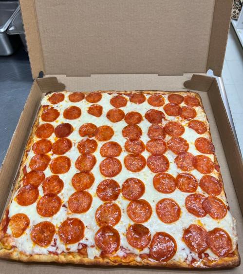 A square pizza topped with numerous slices of pepperoni, placed in an open pizza box.