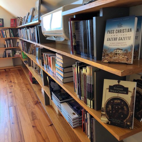 Bookshelves filled with various books, including titles about Pass Christian and the Stennis Space Center.