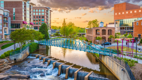 falls park at the reedy and the liberty bridge in greenville south carolina, with a beautiful sunset sky in the background