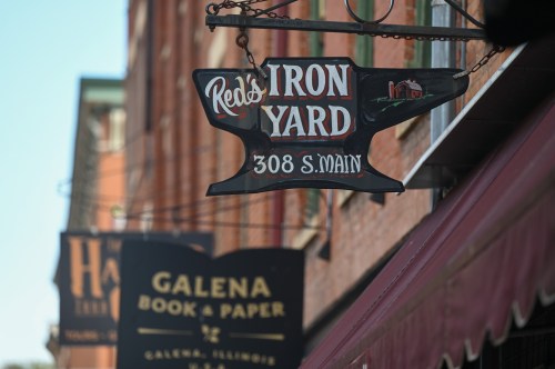 Sign for "Red's Iron Yard" at 308 S. Main, with another sign for "Galena Book & Paper" in the background.