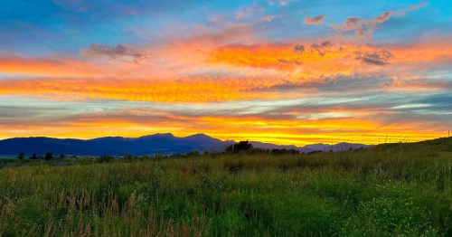A fiery sunset is over the mountains and valleys near Ennis, Montana.