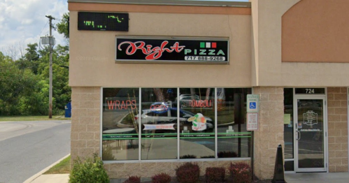 Exterior of Right Pizza restaurant with a sign and large windows displaying menu items.