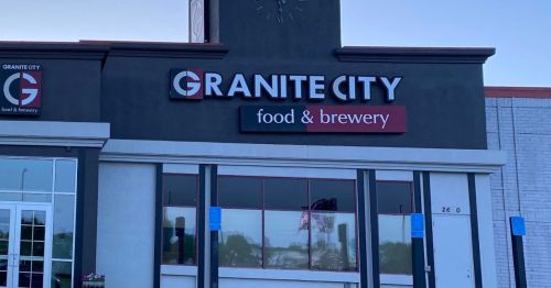 Exterior of Granite City Food & Brewery, featuring a large sign and clock on the building.