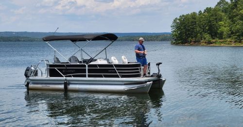 person trying to catch a fish off the side of the boat in Lake Maumelle, Arkansas