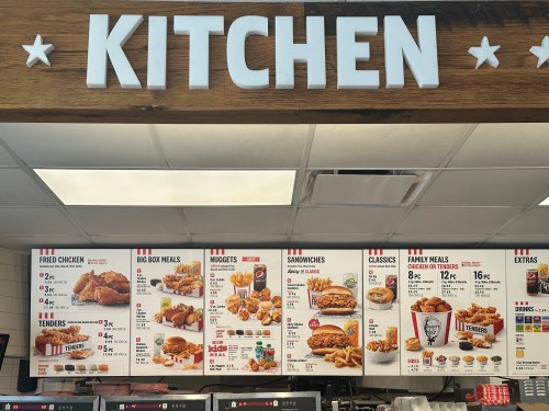 Menu board displaying various meal options including fried chicken, nuggets, sandwiches, and family meals.