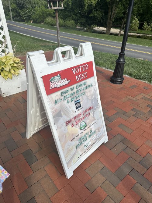 A sign outside a restaurant promoting its awards for best country cooking and breakfast.