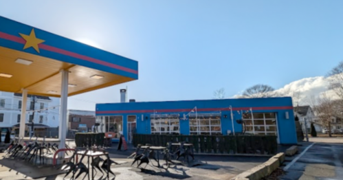 Colorful gas station with a blue and red exterior, featuring a star design and empty bike racks in front.