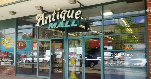 Exterior of an Antique Mall with large windows, showcasing the entrance and nearby street signs.