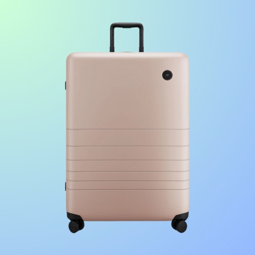 A sleek, light pink suitcase with a retractable handle and wheels, set against a gradient background.