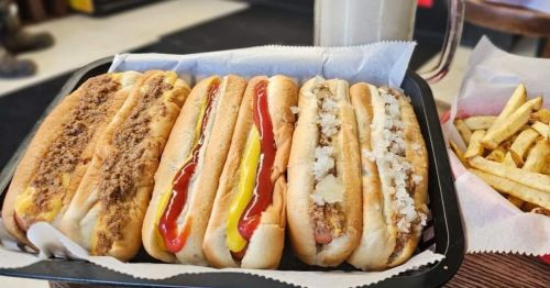A row of hot dogs in a tray at Nick's Jr., a popular hot dog stand in Massachusetts