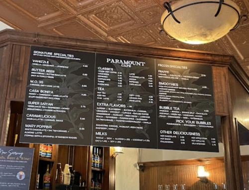 Menu board at Paramount Café featuring drinks and snacks, including specialties, teas, smoothies, and desserts.