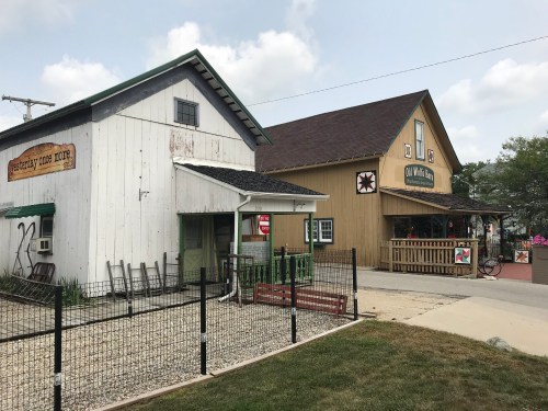 Two rustic buildings side by side, one with a sign reading "Yesterday Once More" and the other "Old Mill Market."