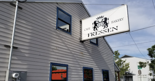 Exterior of Fressen Cafe & Bakery, featuring a sign and windows on a light-colored building.