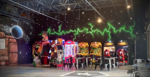 A vibrant arcade with colorful game machines and a cosmic mural on the wall, featuring a futuristic design.