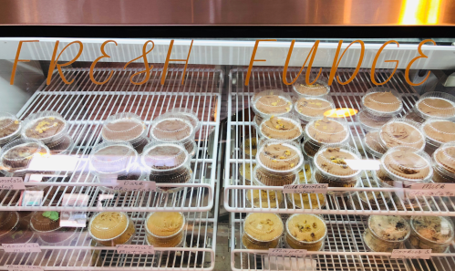 Display case filled with various fudge cups labeled with flavors like chocolate, vanilla, and cookies.