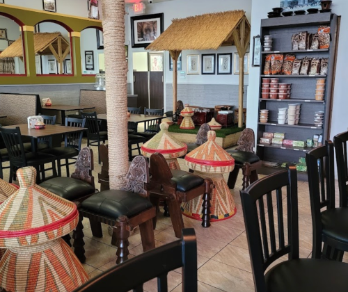 Interior of a restaurant featuring traditional seating, woven baskets, and a decorative hut-like structure.