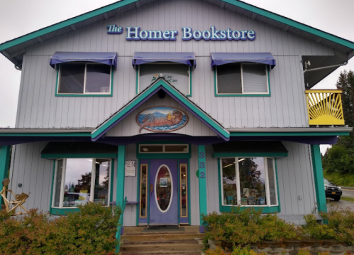 A colorful bookstore with a sign reading "The Homer Bookstore," featuring large windows and a welcoming entrance.