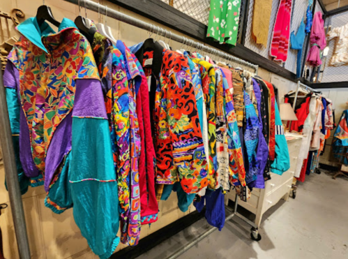 A colorful display of vintage jackets hanging on racks in a boutique, featuring vibrant patterns and designs.