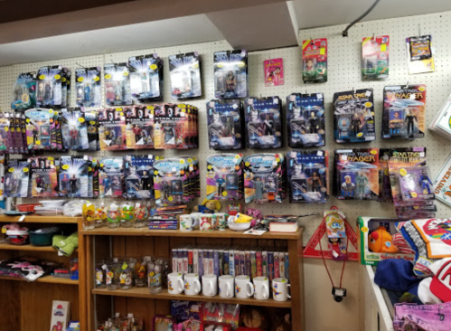 A wall display of various action figures and collectibles, with colorful packaging and a variety of toys in the foreground.