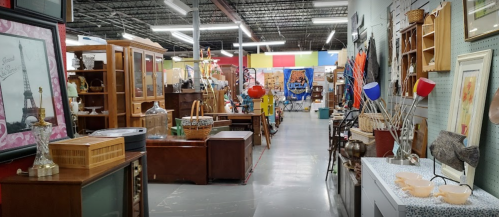 A spacious antique store aisle filled with various vintage furniture and decor items.