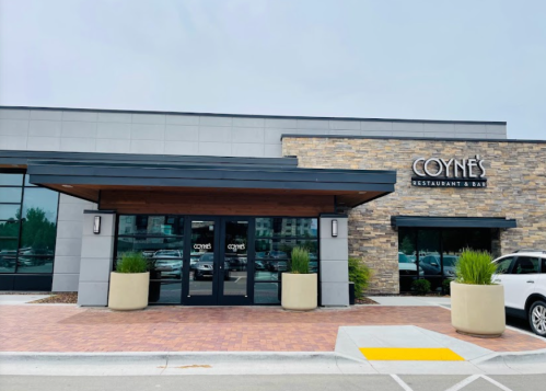 Exterior view of Coyne's Restaurant & Bar, featuring a modern design with stone accents and large glass doors.