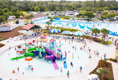 A vibrant water park scene with colorful slides, pools, and families enjoying the sunny day.