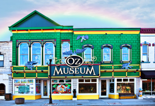 Colorful exterior of the Oz Museum, featuring green walls, decorative elements, and a rainbow in the background.