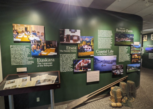 Exhibit showcasing Basque culture, featuring photos, text panels, and artifacts about language, family, and coastal life.