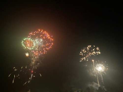 Colorful fireworks burst in the night sky, creating a vibrant display of lights and patterns.