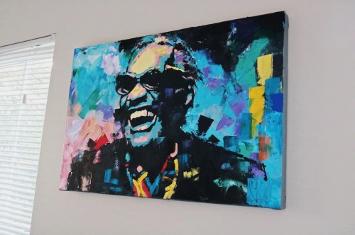 A vibrant abstract painting of a smiling man wearing sunglasses, with colorful brushstrokes in blues and purples.