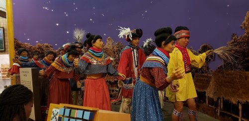 A group of people in traditional attire performing a cultural dance, set against a starry backdrop.