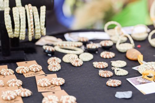 A display of handmade jewelry and accessories, including bracelets and decorative items, on a black tablecloth.