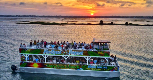 A lively sunset cruise on a boat filled with people, surrounded by water and scenic views.