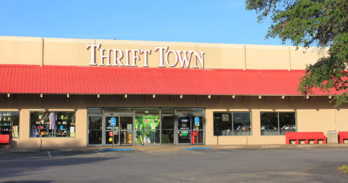 Exterior of Thrift Town store with a red roof, large windows, and a sign displaying the store's name.