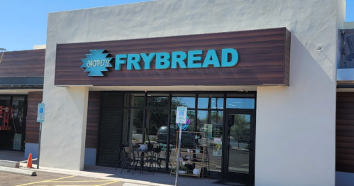 Exterior of a restaurant named "Frybread," featuring a modern design and outdoor seating area.
