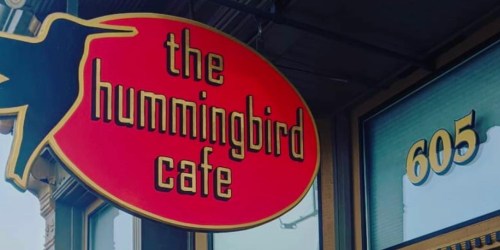 Sign for "The Hummingbird Cafe" in bold red and yellow lettering, located at 605.