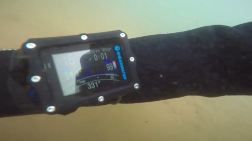 A dive computer displaying depth, time, and other metrics underwater.